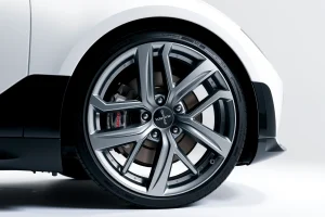 A modern, sleek car wheel with the 'koleso-bestune' branding, displayed on a clean white background with soft studio lighting, highlighting the wheel's design, material texture, and premium finish — no text, logos, or additional elements visible on the wheel itself