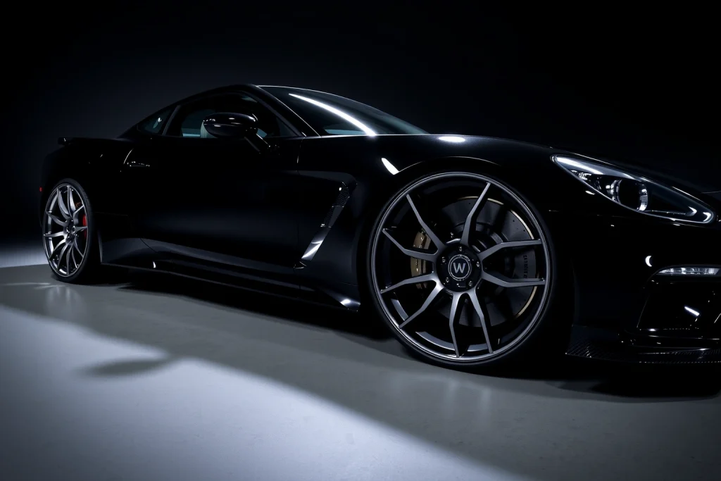 A set of exclusive, high-end custom wheels designed for luxury and performance vehicles, displayed on a sleek black sports car under dramatic studio lighting, with polished chrome and matte black finishes, intricate spoke designs, and subtle carbon fiber accents, emphasizing craftsmanship and exclusivity