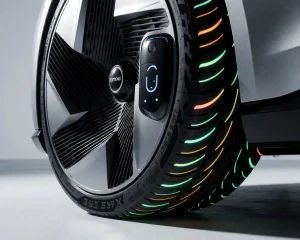 A high-quality, photorealistic close-up of futuristic car wheels named 'Koleso-Bestune' with advanced aerodynamic design, glowing energy-efficient tread patterns, and smart sensor integration visible on the rim, set against a clean, minimalist studio background with soft directional lighting highlighting metallic textures and subtle light reflections