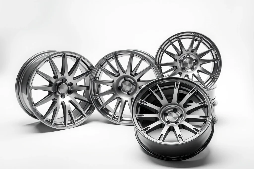 A set of lightweight and durable car wheels made of alloy, displayed on a clean white background with soft lighting, showing intricate spoke design and metallic finish, emphasizing strength and modern engineering
