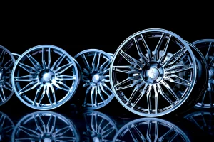 A set of stylish car wheels with modern alloy design, featuring intricate spoke patterns, polished chrome finish, displayed on a dark reflective surface under soft studio lighting, emphasizing elegance and automotive luxury, no text or logos visible