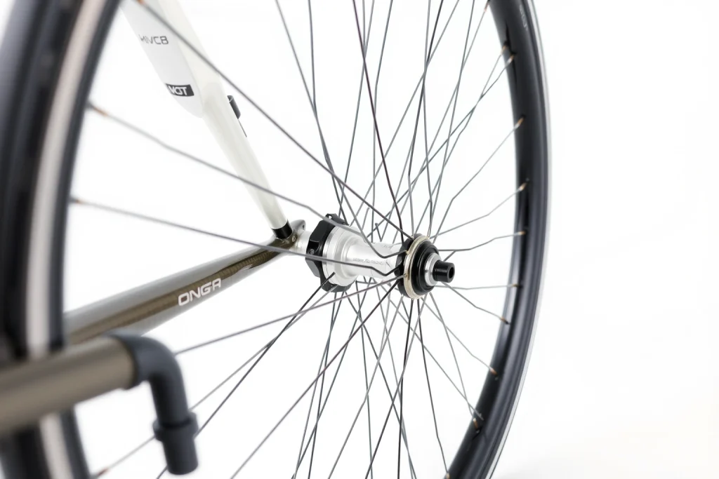 A close-up of a high-quality bicycle wheel with a sleek carbon fiber rim, precision spokes, and a modern hub, displayed on a clean white background with soft natural lighting to highlight texture and detail
